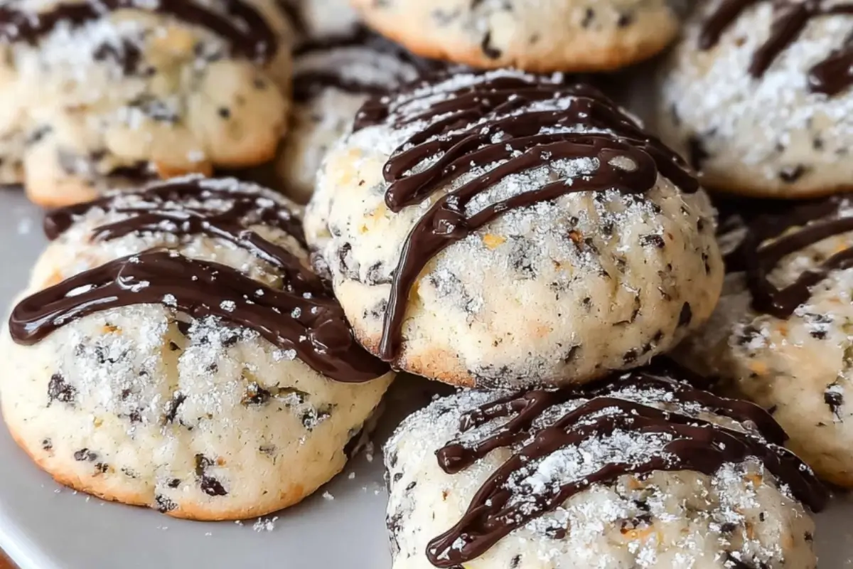 Cannoli Cookies Recipe: The "Bakery-Style" Holiday Favorite (Without the Fryer) Cannoli Cookies Recipe A close-up of soft Italian cannoli cookies drizzled with melted chocolate and dusted with powdered sugar, highlighting their ricotta texture and mini chocolate chips for this cannoli cookies recipe.