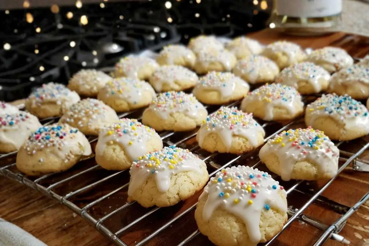 Nonna's Soft Italian Lemon Drop Cookies (Melt In Your Mouth) Italian Lemon Drop Cookies A plate of Authentic Italian Lemon Cookies, soft and golden, with a light dusting of powdered sugar and a hint of lemon zest, arranged on a rustic wooden table.