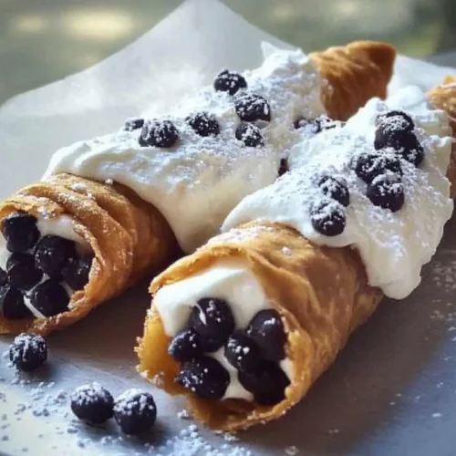 Authentic Cannoli with Ricotta And Chocolate Chips: Nonna's Secret to the Perfect Holiday Crunch Cannoli with Ricotta and Chocolate Chips Two homemade ricotta cannoli on a rustic plate, filled with creamy ricotta and studded with chocolate chips, dusted lightly with powdered sugar.