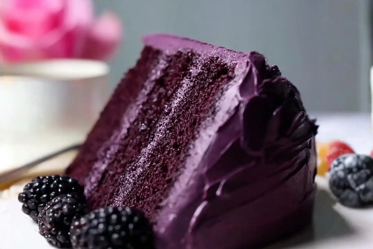 The Dreamiest Blackberry Velvet Cake (A Foolproof, No-Dye Recipe for Your Next Gathering) Dreamiest Blackberry Velvet Cake A rich, tender slice of dark purple blackberry velvet cake with thick, glossy berry frosting, served on a vintage white plate with a gold rim and garnished with fresh, plump blackberries.