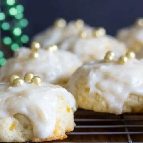 Italian Orange Ricotta Cookies: Nonna’s Make-Ahead Holiday Centerpiece Italian Orange Ricotta Cookies A plate of Italian orange ricotta cookies dusted with powdered sugar, with a soft, golden texture, arranged on a rustic wooden table.