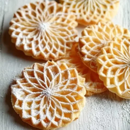 Perfect Italian Pizzelle Cookies for Sweet Memories Italian Pizzelle cookies A stack of golden Italian pizzelle cookies with delicate patterns, dusted lightly with powdered sugar on a rustic wooden board.