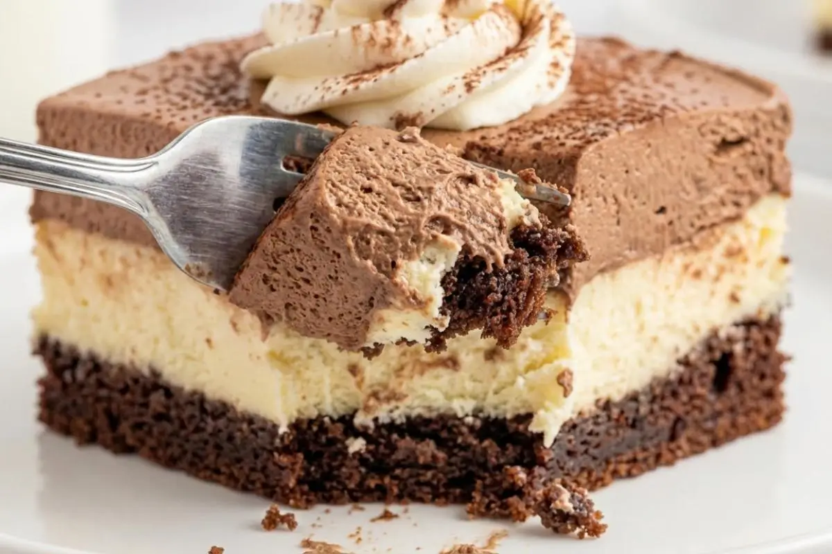 Popular Variations Classic & Experimental A close-up of a silver fork lifting a generous bite from a layered slice of cake, highlighting the creamy textures and rich frosting of these delicious Italian Love Cake variations.