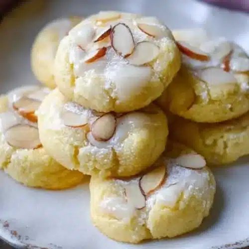 Almond Meltaway Cookies: My 20-Minute Secret to a Bakery-Perfect Holiday Tray Almond Meltaway Cookies A plate of delicate almond meltaway cookies dusted with powdered sugar, set on a rustic wooden table with soft natural light, highlighting their buttery texture.
