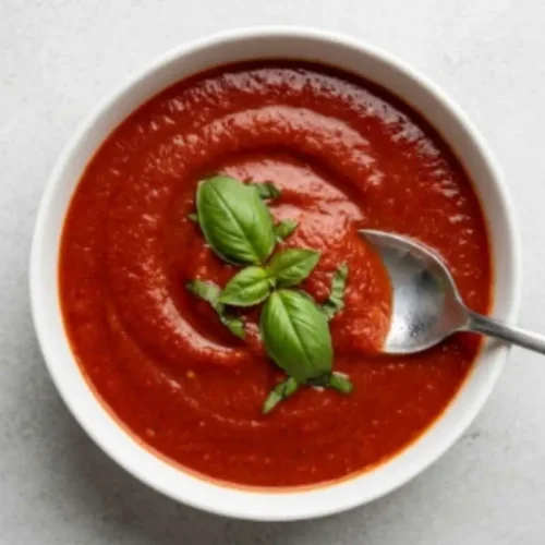 Authentic Italian Sunday Sauce: The Nostalgic Recipe That Brings Family Together Italian Sunday Sauce A bowl of authentic Italian Sunday sauce made with slow-simmered tomatoes, garlic, onion, and fresh basil, garnished with basil leaves and ready to serve.