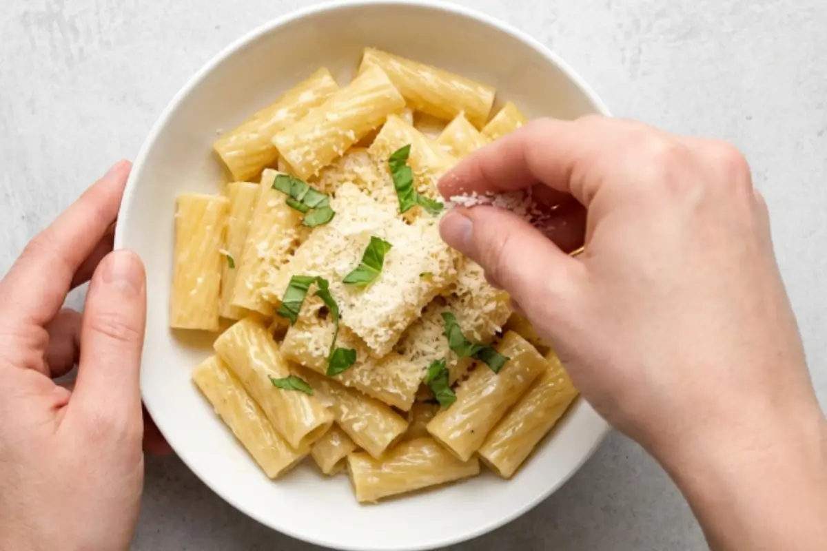 comforting-garlic-parmesan-pasta-serving-bowl A bowl of creamy rigatoni topped with freshly grated Parmesan and herbs for The Most Comforting Garlic Parmesan Pasta recipe.
