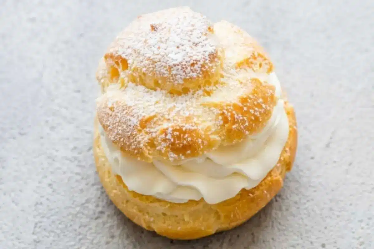 The Most Heavenly Cream Puff Filling Recipe (A 10-Minute Stress-Free Shortcut!) cream puff filling recipe A homemade cream puff filled with rich cream puff filling and dusted with powdered sugar on top.