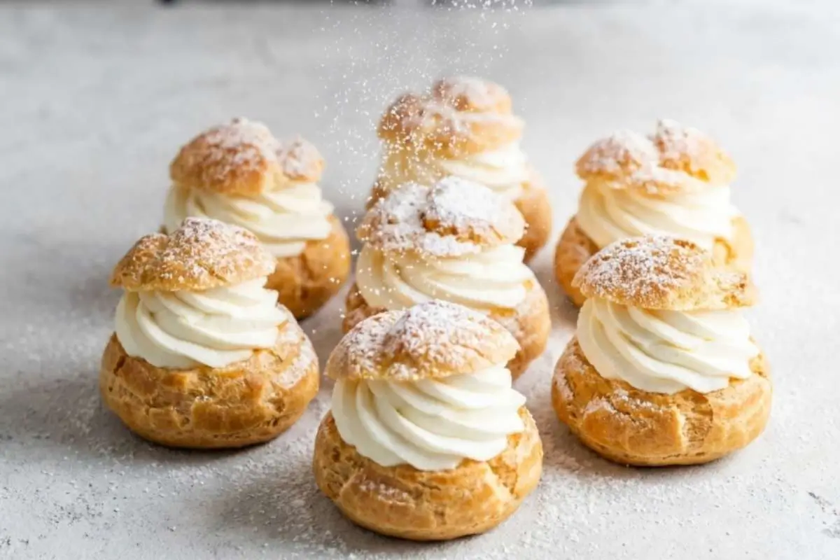 heavenly-cream-puff-filling-recipe-finished-cream-puffs Homemade cream puffs filled with fluffy cream puff filling and dusted with powdered sugar for The Most Heavenly Cream Puff Filling Recipe.