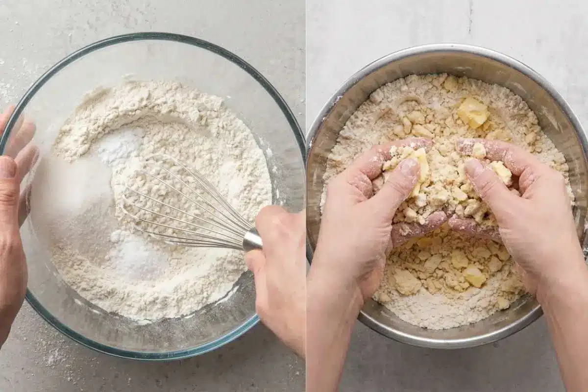 white-chocolate-raspberry-cake-recipe-crumb-mixture Hands mixing butter into flour for a white chocolate raspberry cake recipe, creating a soft crumb mixture in a metal bowl.