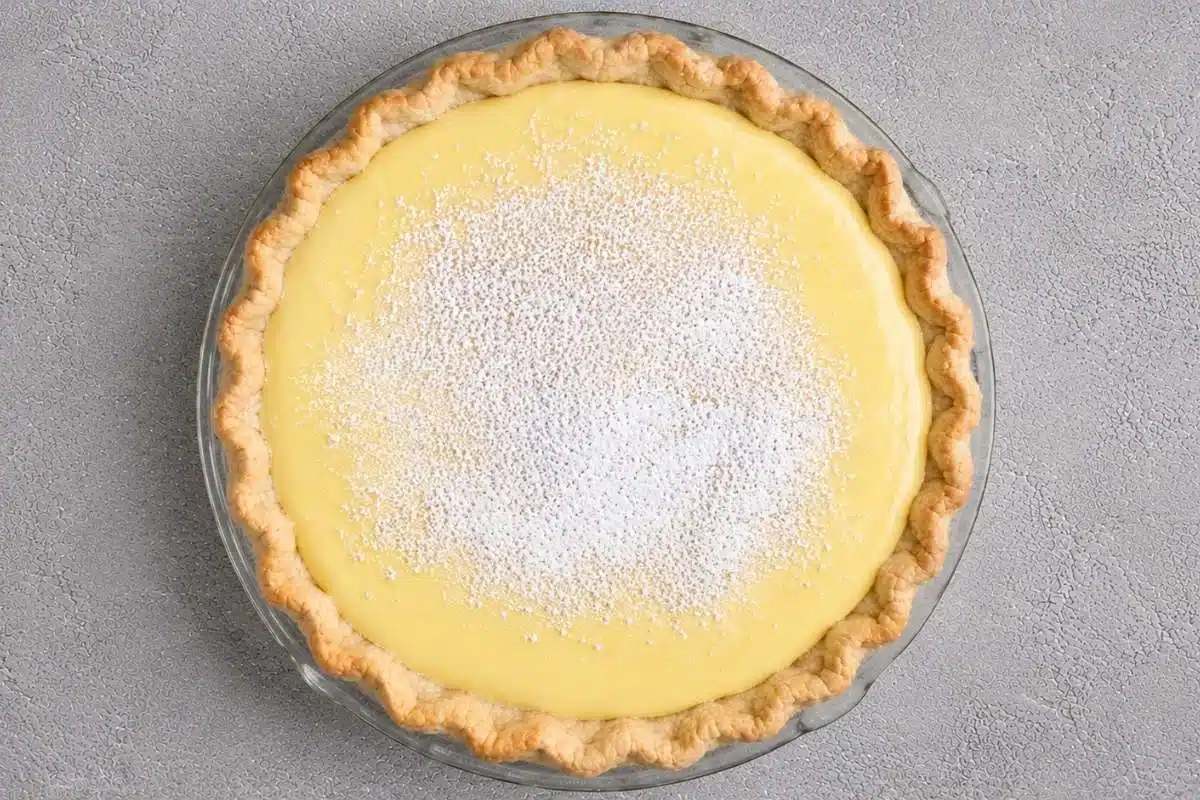 creamy-lemon-ricotta-pie-whole Overhead view of a Creamy Lemon Ricotta Pie in a flaky golden crust, topped with a generous dusting of powdered sugar and ready to serve.